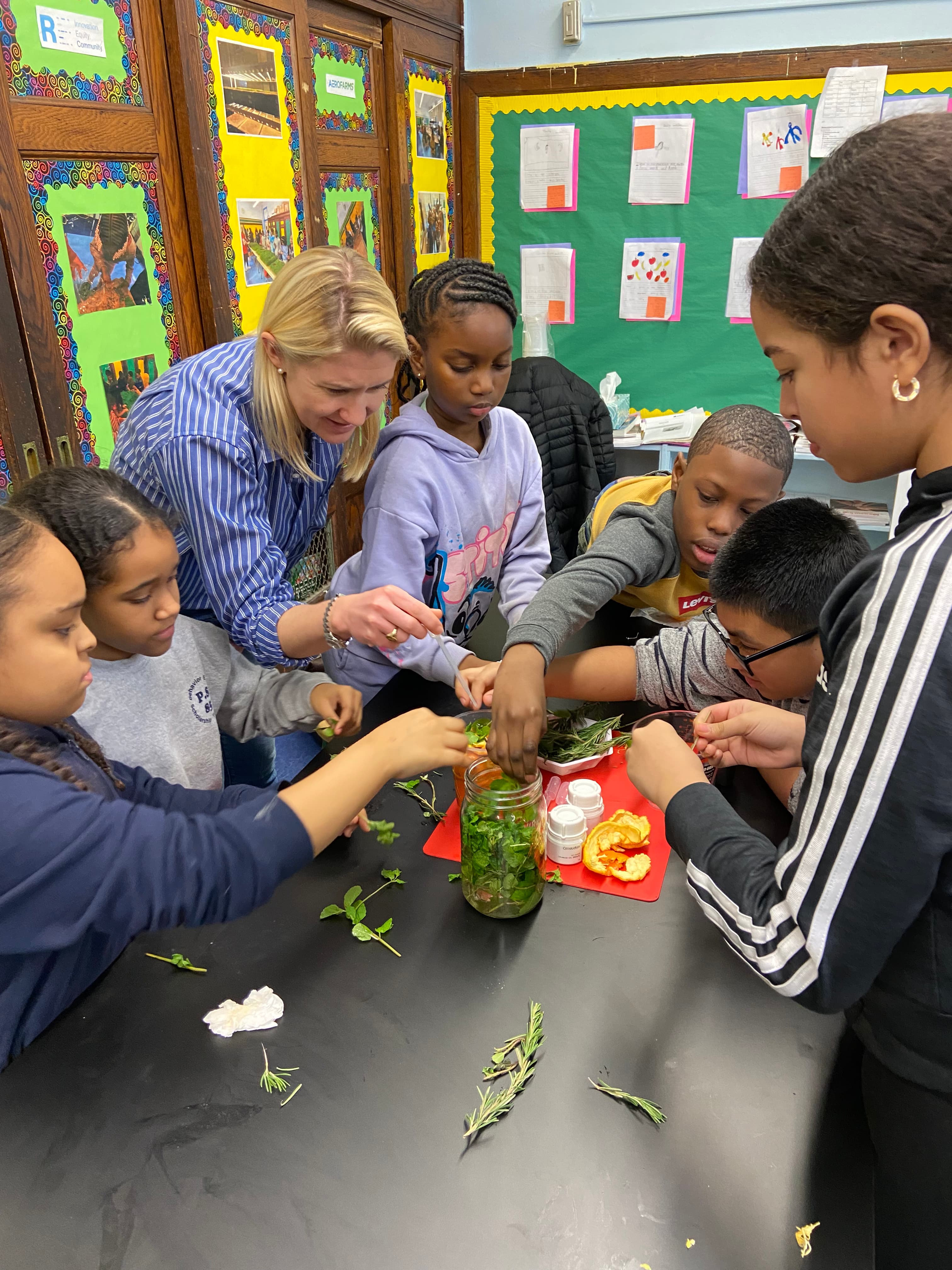 Givaudan volunteer together with students making herb bundles